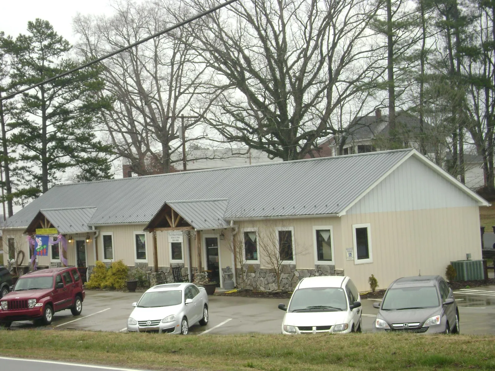 Gray metal roof with timber entry brackets on a small commercial building in Smith
