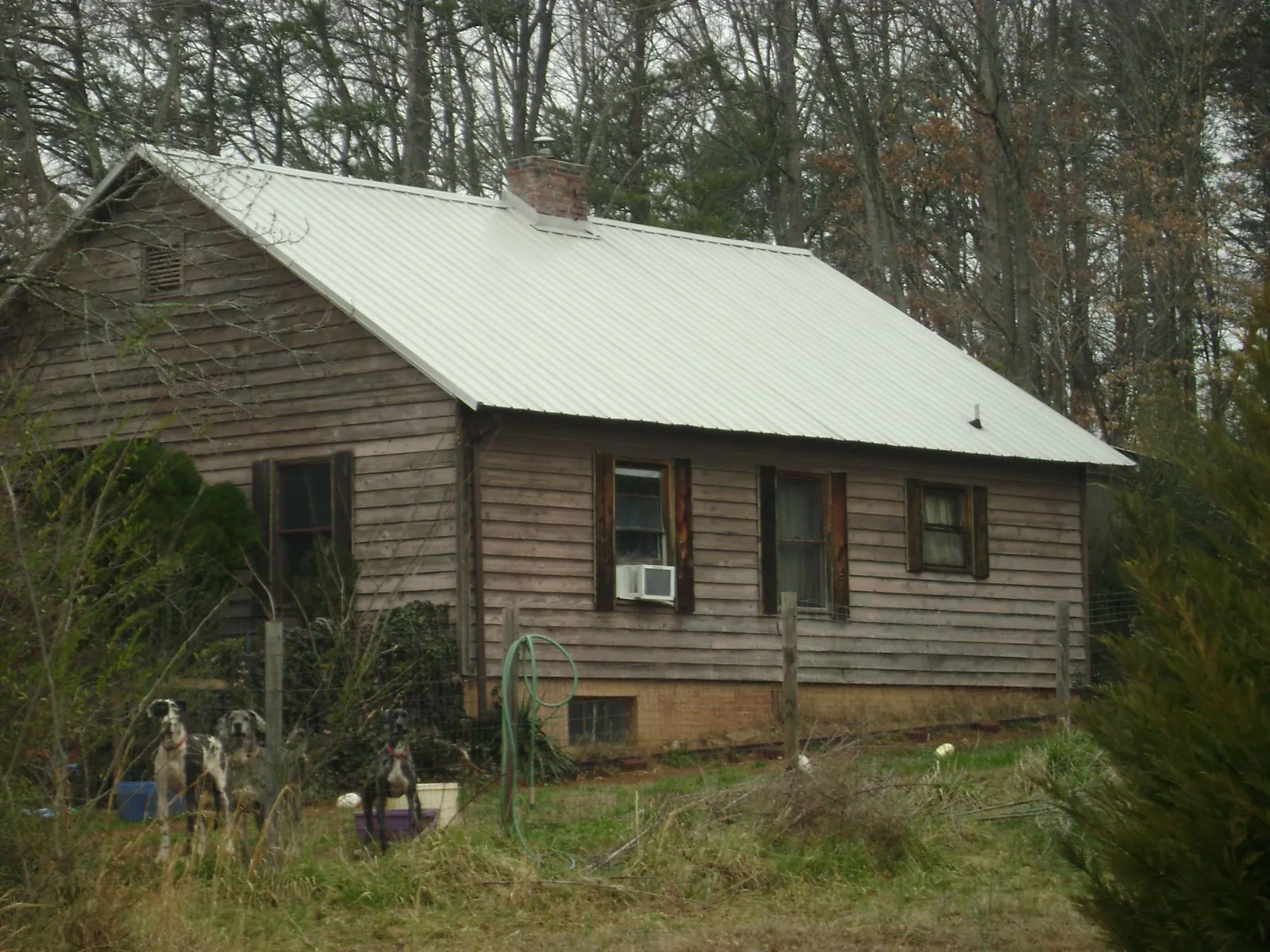 White metal roof on an old wood sided farmhouse, from a Metal Roof Installation job in Smith